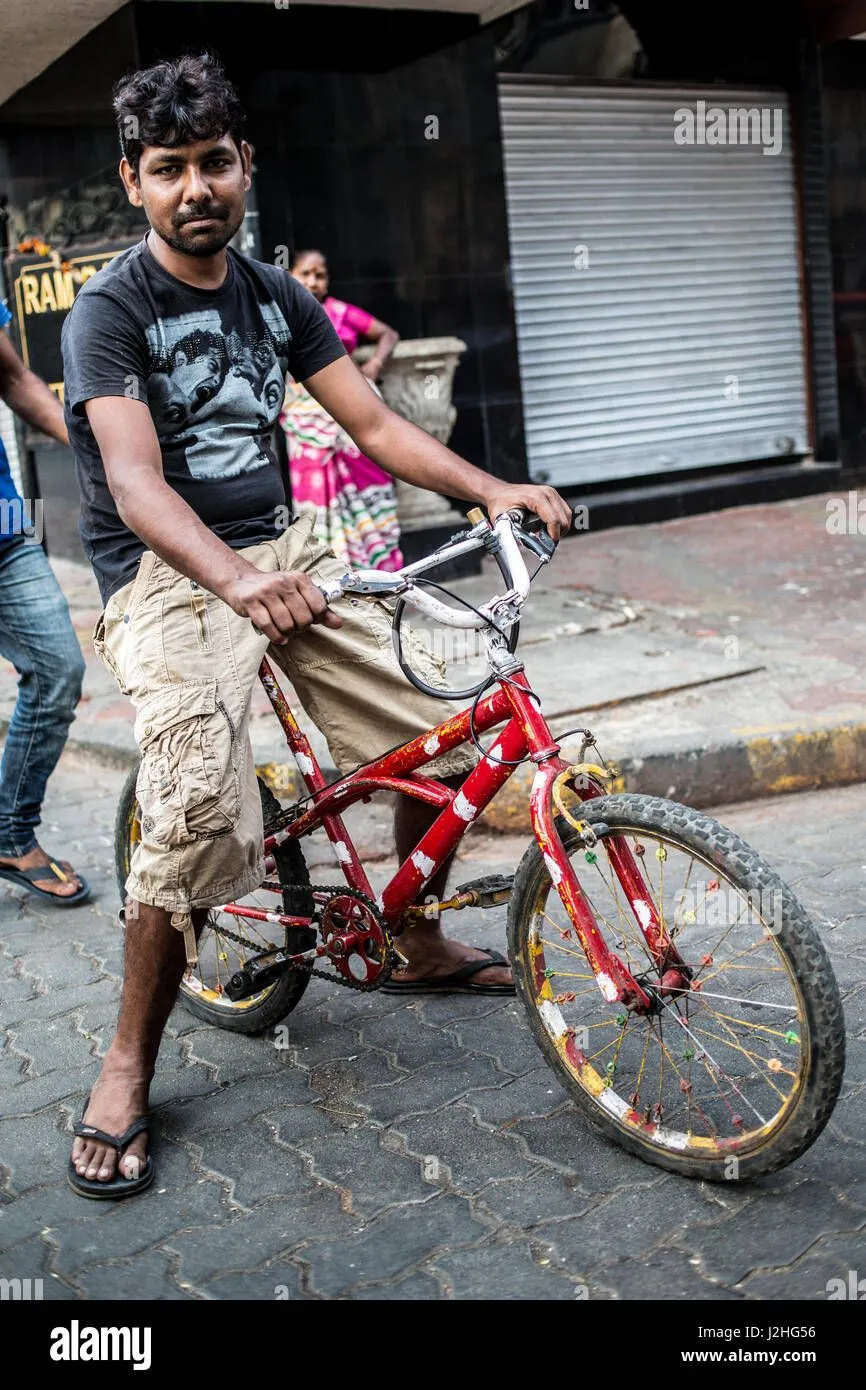 a-indian-man-sitting-on-a-bicycle-in-mumbai-J2HG56.webp