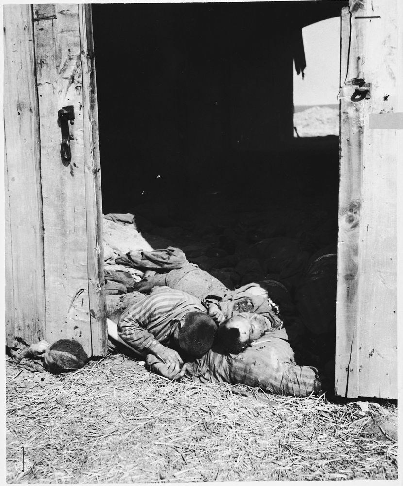 A pile of charred corpses lie near the southeast door of the barn outside of Gardelegen.jpg