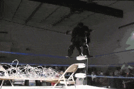 Avalanche Butterfly Suplex to a Table with Barbed Wire.gif