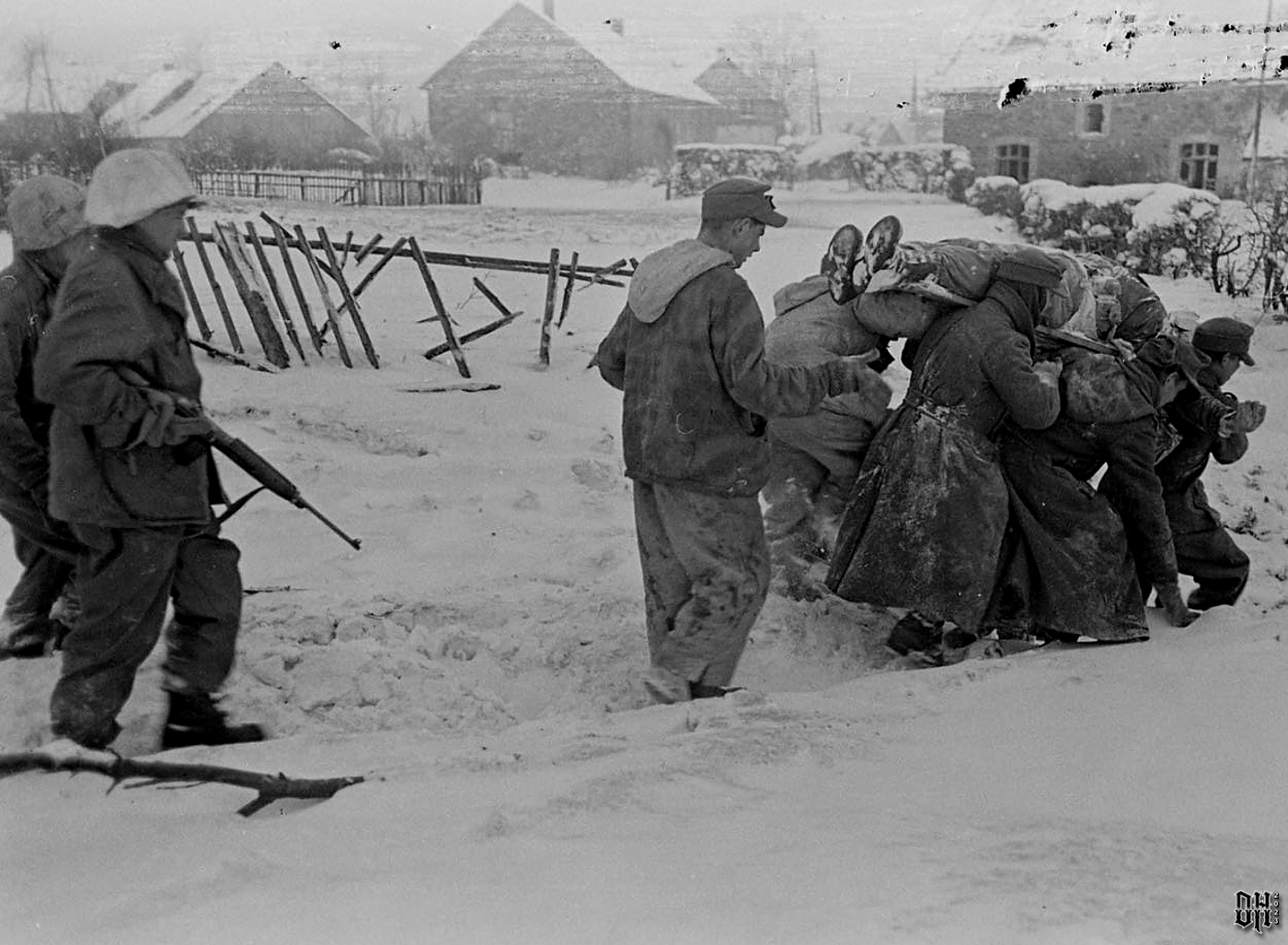 DH - Dead US Soldiers 14- Dead Soldier Being Moved by German POWs - Battle of Bulge.jpg