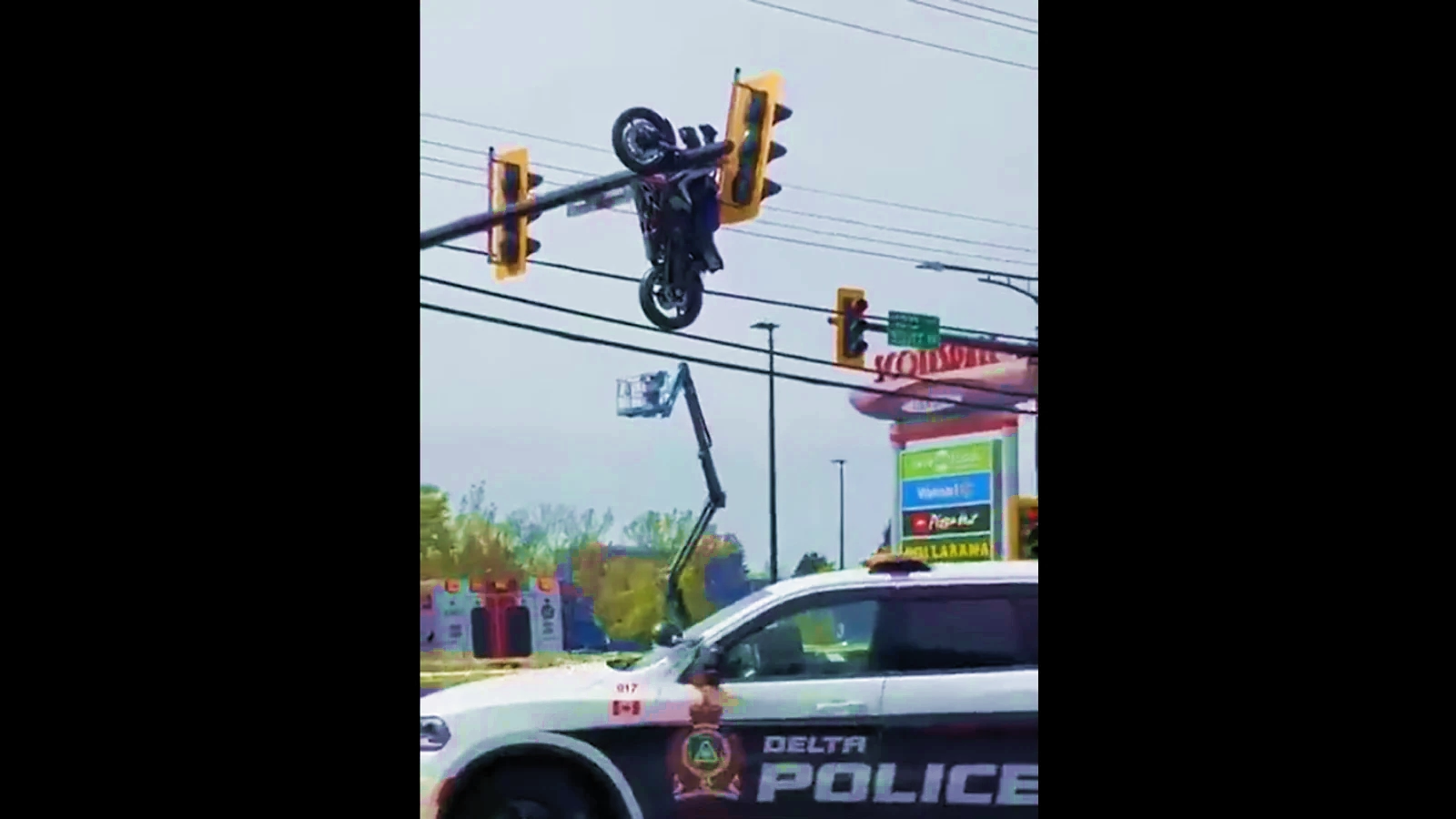 Motorcyclist crashes into car, bike ends up dangling from traffic lights, rider was injured 1...webp