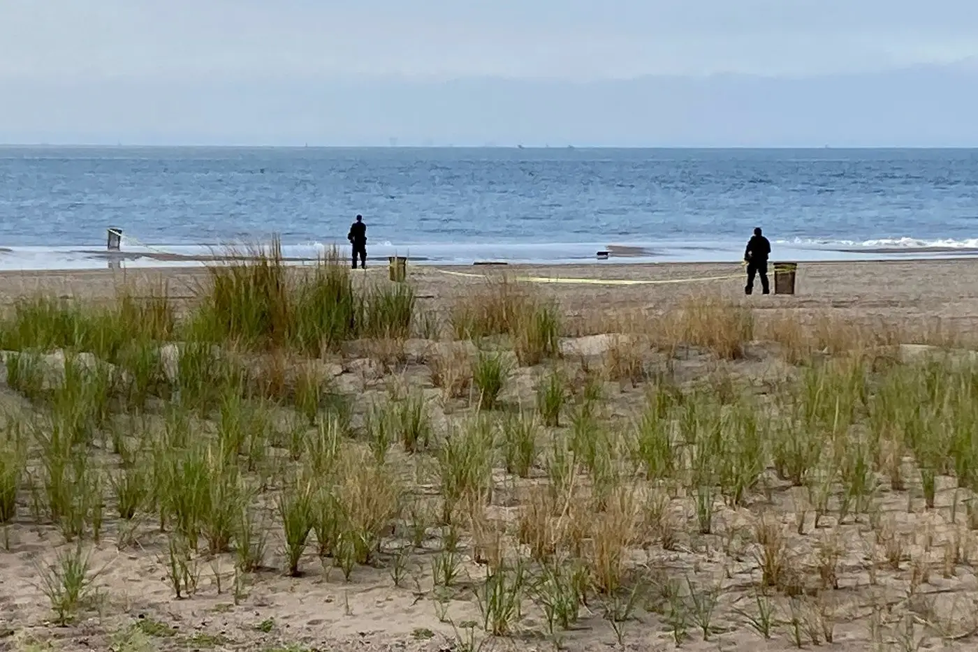 New York Police investigators examine a stretch of beach at Coney Island where three children...webp