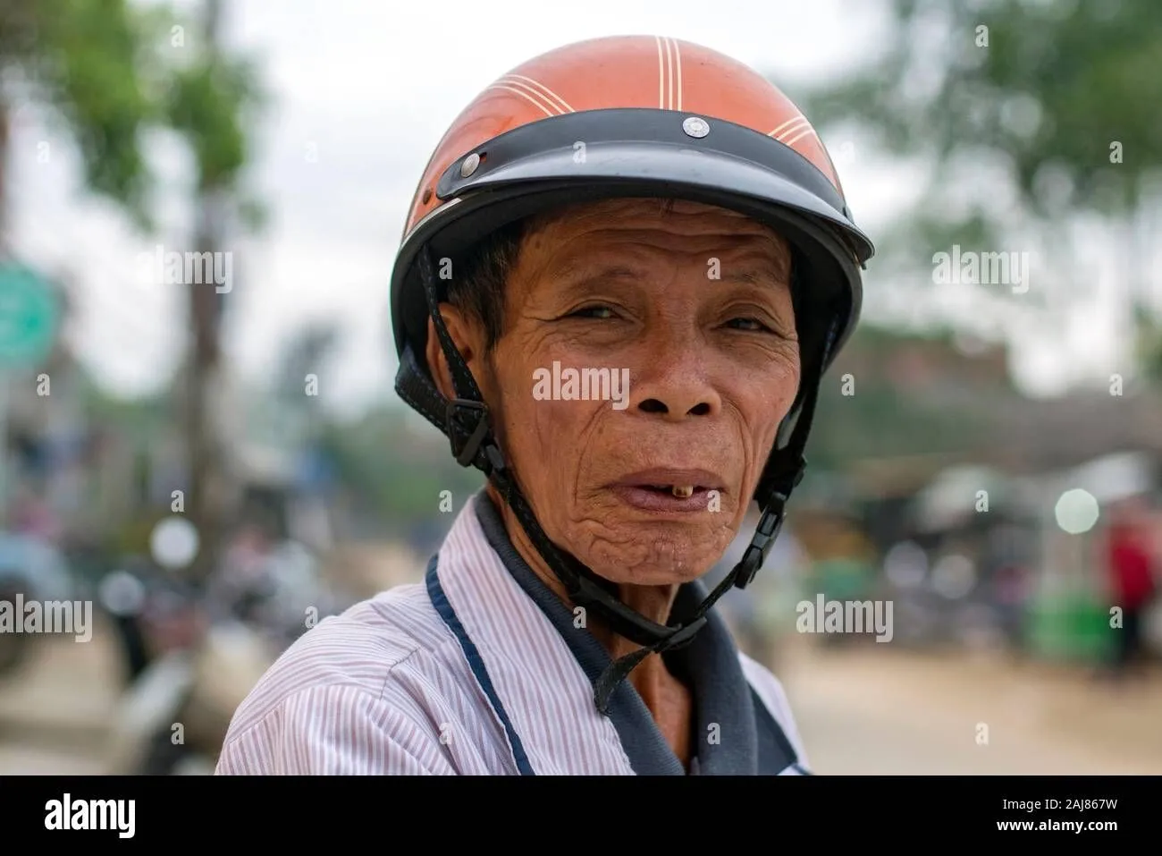 portrait-of-an-old-asian-man-with-a-helmet-2AJ867W.jpg