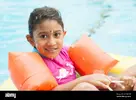 portrait-of-cute-smiling-girl-wearing-water-wings-in-swimming-pool-2DN4YDG.webp